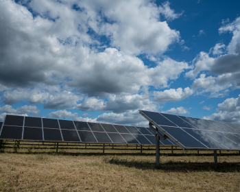 Solar panels used for renewable energy on the field under the sky full of clouds